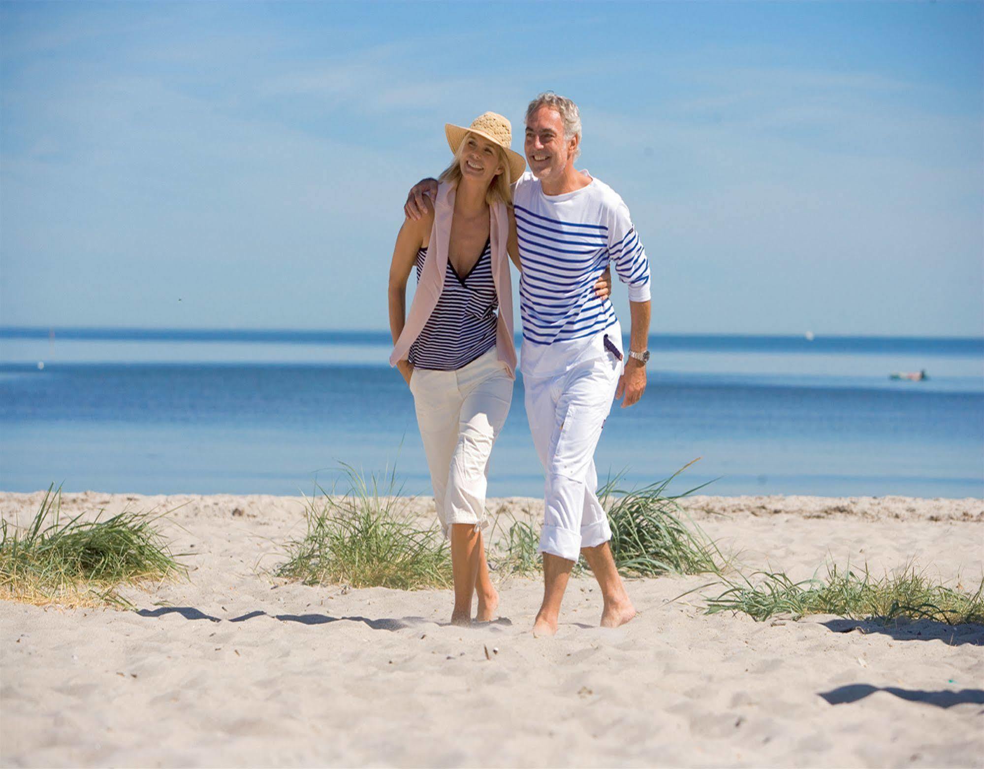 Hotel Yachthafenresidenz Hohe Duene Rostock Esterno foto A couple walking on the beach